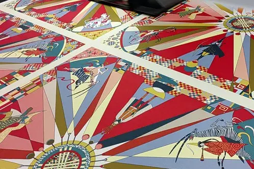 Printed scarf panels laid flat with red, beige and black graphic artwork