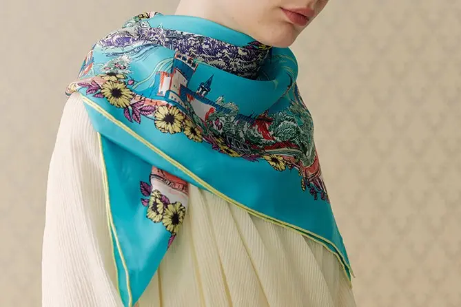 Turquoise scarf with architectural and floral artwork