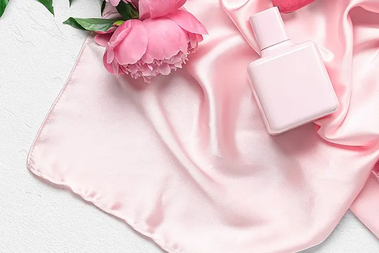 Pink silk scarf arranged with matching flowers and gift accessories