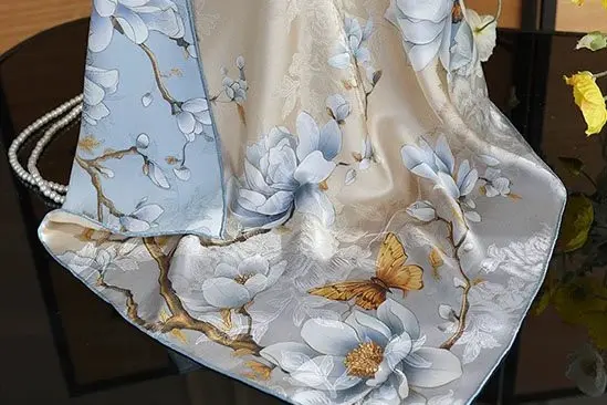 Ivory silk scarf draped to show a blue magnolia and butterfly print