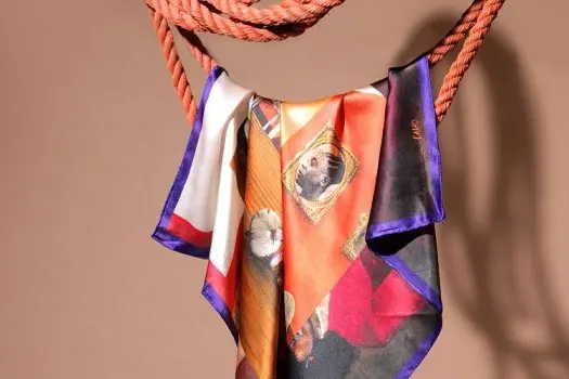 Colorful artist-print silk scarf displayed against a neutral backdrop