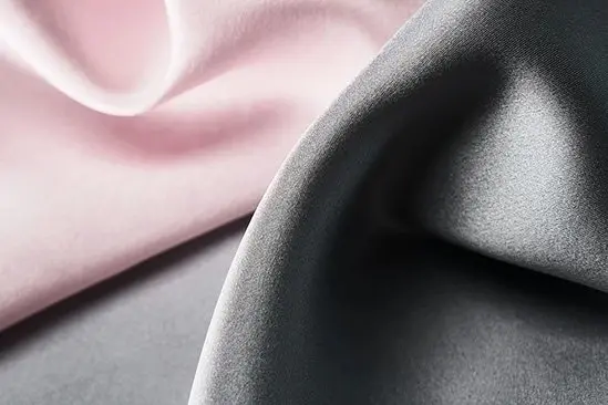 Pink and charcoal silk fabrics showing smooth surfaces and fluid drape