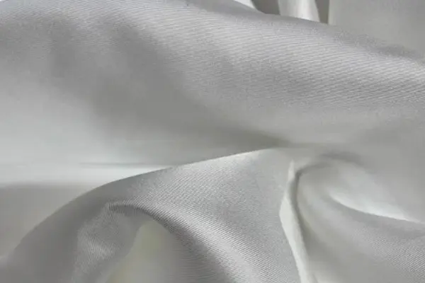 White silk twill fabric showing its diagonal weave and soft drape