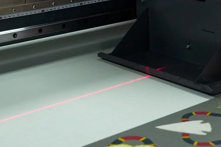 Digital textile printer using a laser guide to align fabric and artwork