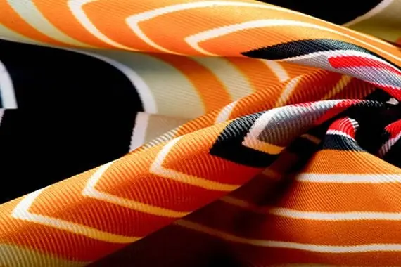 Orange, black and white screen-printed fabric showing clean color edges and surface texture