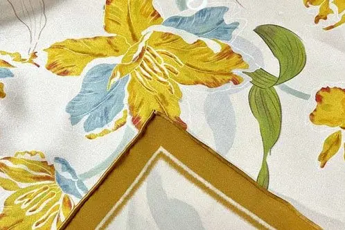 Folded printed silk scarf showing contrasting face and reverse colors