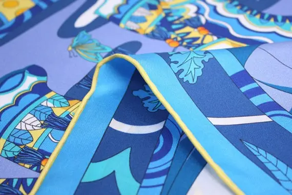 Close-up of blue printed scarf fabric showing color and edge piping