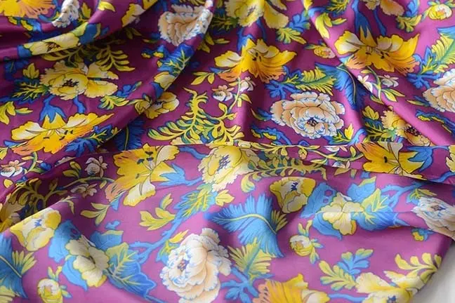 Colorful floral print across draped silk satin fabric