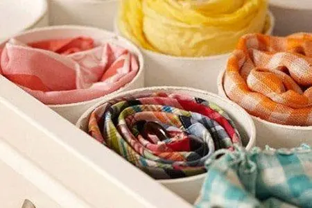 Several rolled scarves arranged by colorway to show collection variety