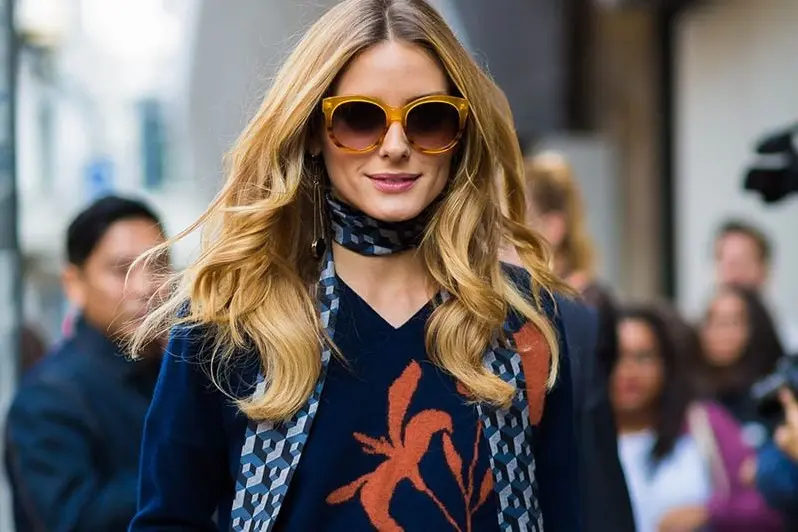 Long patterned silk scarf worn with a knit sweater for light winter layering