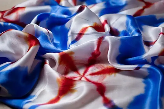 Printed silk satin gathered into folds to show its sheen and fluid drape