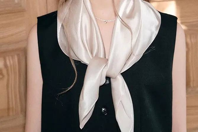 Compact solid silk scarf tied at the neck to show a smaller styling proportion