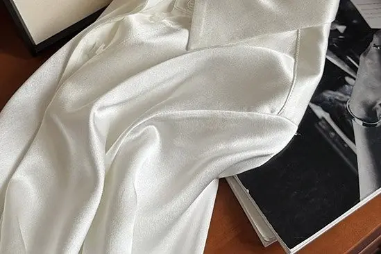 Light satin fabric draped with visible creases before wrinkle removal