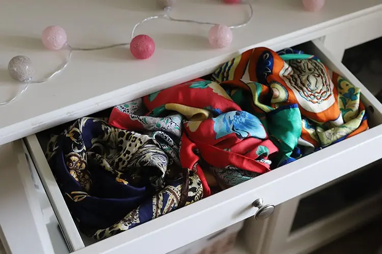 Printed scarves gathered tightly in a drawer where fixed folds can create creases