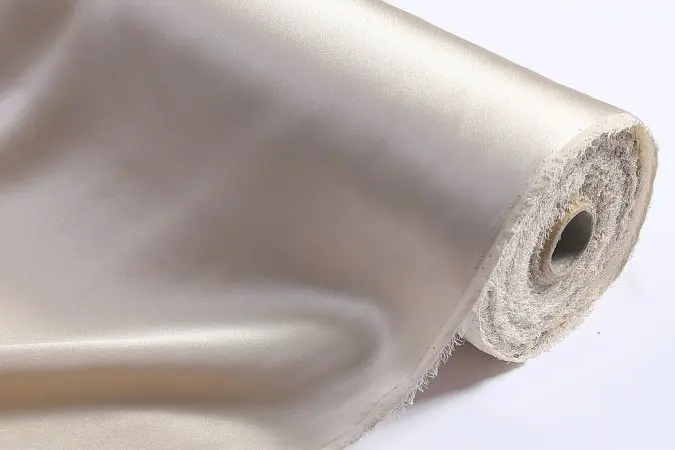 Champagne silk fabric unrolled to show drape and fold behavior