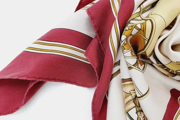 Printed silk scarf with dark red, cream and gold areas that require color-conscious stain care