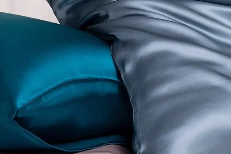 Blue and teal silk pillowcases arranged to show their smooth surface and drape